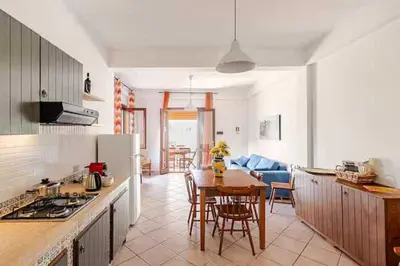 a kitchen and living room with a table and chairs at Villa Rossa by Sicily Travelling Villas in Scopello