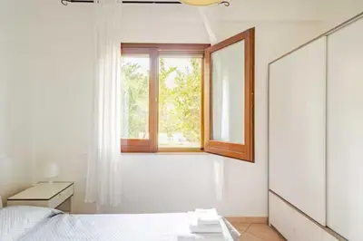 a bedroom with a window and a bed and a mirror at Villa Bianca by Sicily Travelling Villas in Castellammare del Golfo