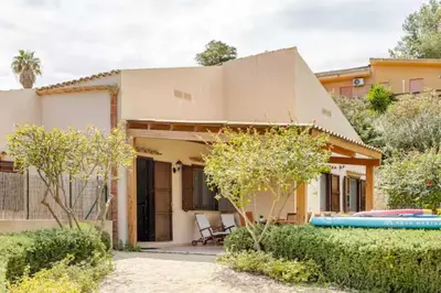 a house with a surfboard in front of it at Villa Bianca by Sicily Travelling Villas in Castellammare del Golfo
