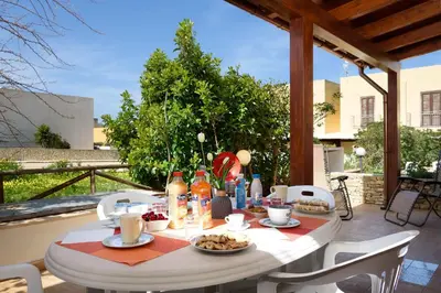 a kitchen and dining room with a table and chairs at Trilocale Piano Terra Con Veranda in San Vito lo Capo