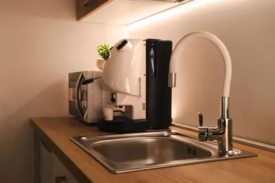 a coffee maker sitting on top of a kitchen sink at Papireto Rooms in Palermo