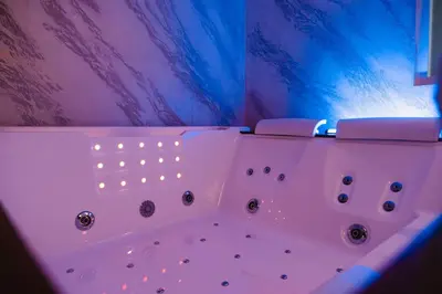 a white bath tub with lights in a bathroom at Papireto Rooms in Palermo