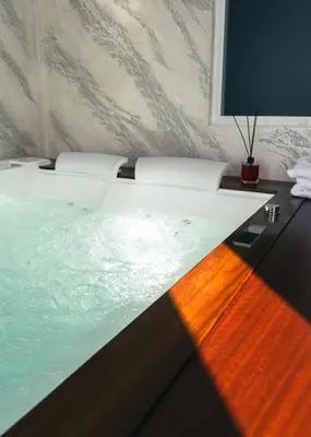 a room with a bath tub with a table and a television at Papireto Rooms in Palermo