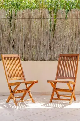 two wooden chairs sitting next to a fence at Villa Disa by Sicily Travelling Villas in Castellammare del Golfo