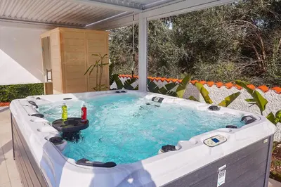 a jacuzzi tub with a drink in it at Villa the Twins in Castellammare del Golfo