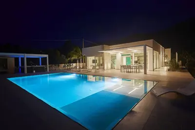 a swimming pool in front of a house at night at Villa the Twins in Castellammare del Golfo