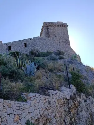 an old building on top of a rocky hill at Guarda l'alba in Altavilla Milicia