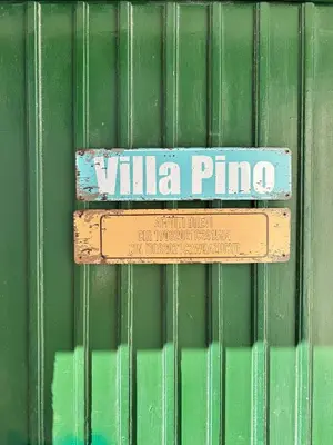 a sign that reads villa pino on a green wall at Villa Pino in Carini