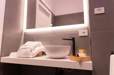 a bathroom with a sink and a bowl on a shelf at Quattro Canti Deluxe in Palermo