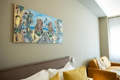 a painting hanging above a bed in a room at Quattro Canti Deluxe in Palermo