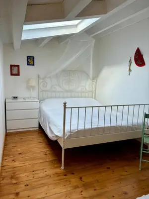 a bedroom with a white bed and a chair at Casa Vacanze Sfera 6 in Palermo