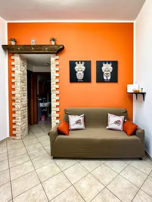 a couch in a living room with an orange wall at Balat City in Palermo