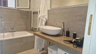 a bathroom with a white bowl sink on a counter at Brunetto House in Palermo