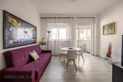 a living room with a purple couch and a table at Chez Gabriel by DomuSicily in Palermo