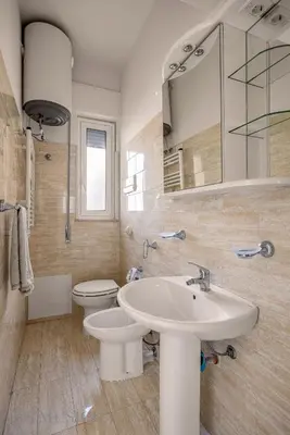 a bathroom with a sink and a toilet and a mirror at Chez Gabriel by DomuSicily in Palermo