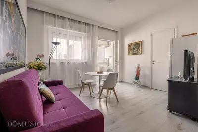 a living room with a purple couch and a table at Chez Gabriel by DomuSicily in Palermo