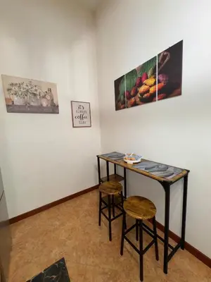 a table and two stools in a room with paintings at Suli D'amuri in Palermo