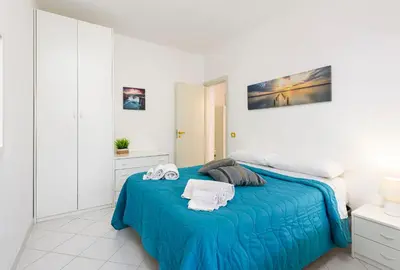 a bedroom with a blue bed with towels on it at Trilocale Mulino Superior in San Vito lo Capo