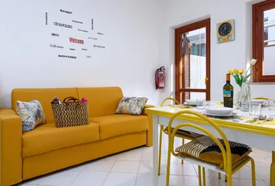 a living room with a yellow couch and a table at Trilocale Mulino Superior in San Vito lo Capo