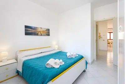 a bedroom with a bed with towels and slippers at Trilocale Mulino Superior in San Vito lo Capo
