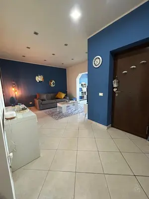 a living room with a couch and a clock on a blue wall at Casa Aura in Palermo