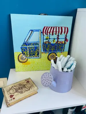 a desk with a painting and a cup of pens at Casa Aura in Palermo
