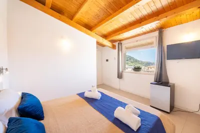 a bedroom with a large bed and a large window at Opera Suite in Castellammare del Golfo