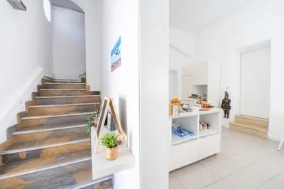 a staircase in a building with white walls and wooden floors at Opera Suite in Castellammare del Golfo