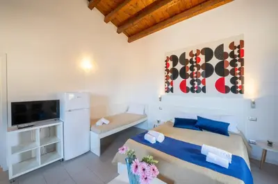 a bedroom with a bed and a flat screen tv at Opera Suite in Castellammare del Golfo