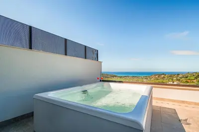 a bath tub on a balcony with a view of the ocean at Villa Brezza in Partinico