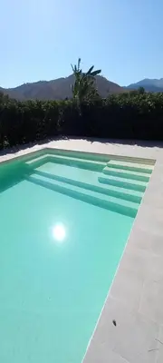 a large swimming pool with blue water in a yard at Villa Elios Adriana con piscina a Lascari in Lascari