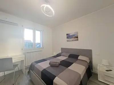 a bedroom with a bed and a desk and window at Villa Elios Adriana con piscina a Lascari in Lascari