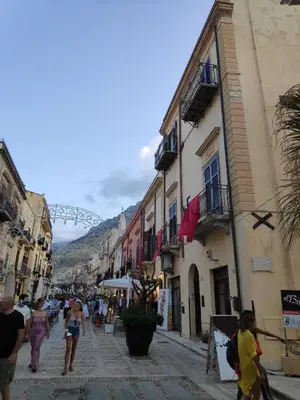 a group of people walking down a street with buildings at Dimore Barraco - SiciliaDaMare in Castellammare del Golfo