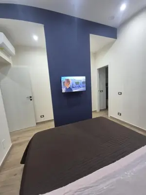 a bedroom with a large bed with a blue wall at Trinacria Guest house in Palermo
