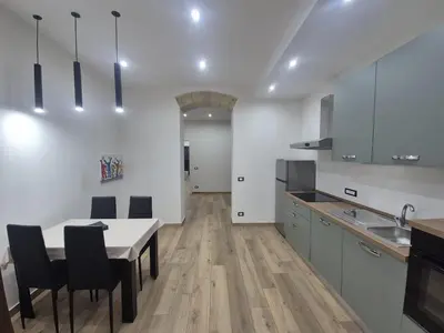 a kitchen with a table and chairs and a kitchen with white walls at Trinacria Guest house in Palermo