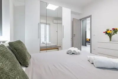 a bedroom with a white bed with two towels on it at GuestHost - Sicilian Dream - Modern Central Apartment in Palermo