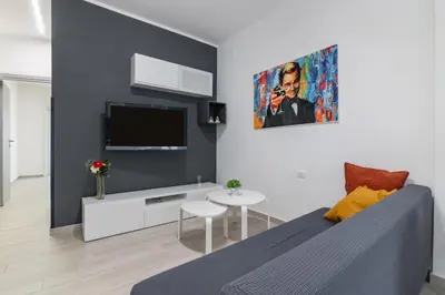 a living room with a couch and a tv at GuestHost - Sicilian Dream - Modern Central Apartment in Palermo
