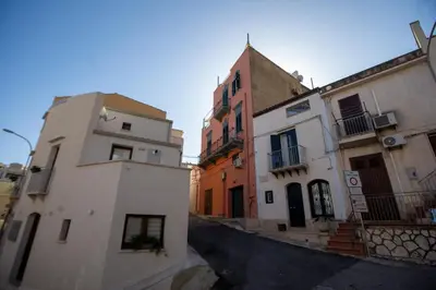 a kitchen with white cabinets and a stove top oven at Casa del Porto in Castellammare del Golfo