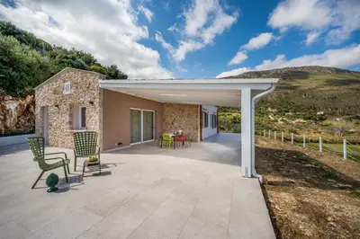 a large patio with chairs and a house at Villa Orizzonte in Scopello