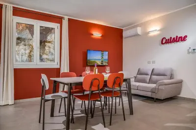 a dining room with a table and chairs and a couch at Villa Orizzonte in Scopello