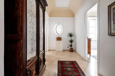 a hallway with a large wooden cabinet and a rug at TorreKalsa Apartment by Wonderful Italy in Palermo