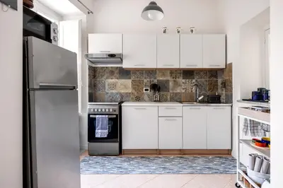 a kitchen with white cabinets and a refrigerator at TorreKalsa Apartment by Wonderful Italy in Palermo