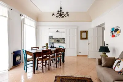 a dining room and living room with a table and chairs at TorreKalsa Apartment by Wonderful Italy in Palermo