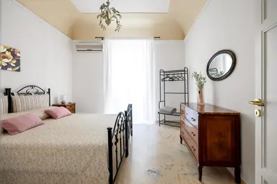 a bedroom with a bed and a dresser and a mirror at TorreKalsa Apartment by Wonderful Italy in Palermo
