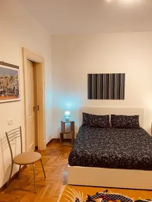 a bedroom with a bed and a table and a chair at la casa di Tati Palermo centro in Palermo