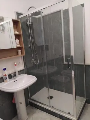 a shower with a glass door next to a sink at la casa di Tati Palermo centro in Palermo