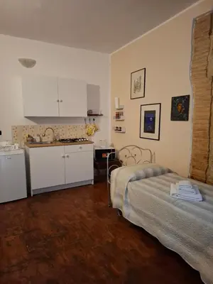 a bedroom with a bed and a kitchen with a sink at Tiny House in Palermo