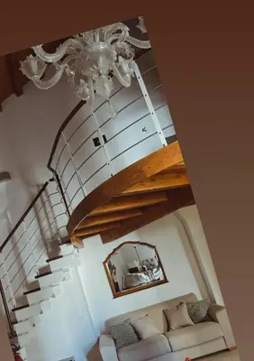 a living room with a staircase with a chandelier at I Tamarindi in Palermo