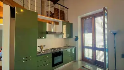 a green kitchen with a stove and a window at I Tamarindi in Palermo