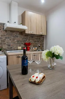 a table with a bottle of wine and two glasses at QuattroCantiApartment2 Palermo in Palermo